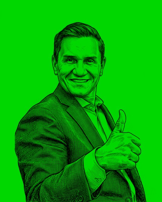 A man in a suit giving a thumbs-up gesture against a bright green background, smiling confidently.