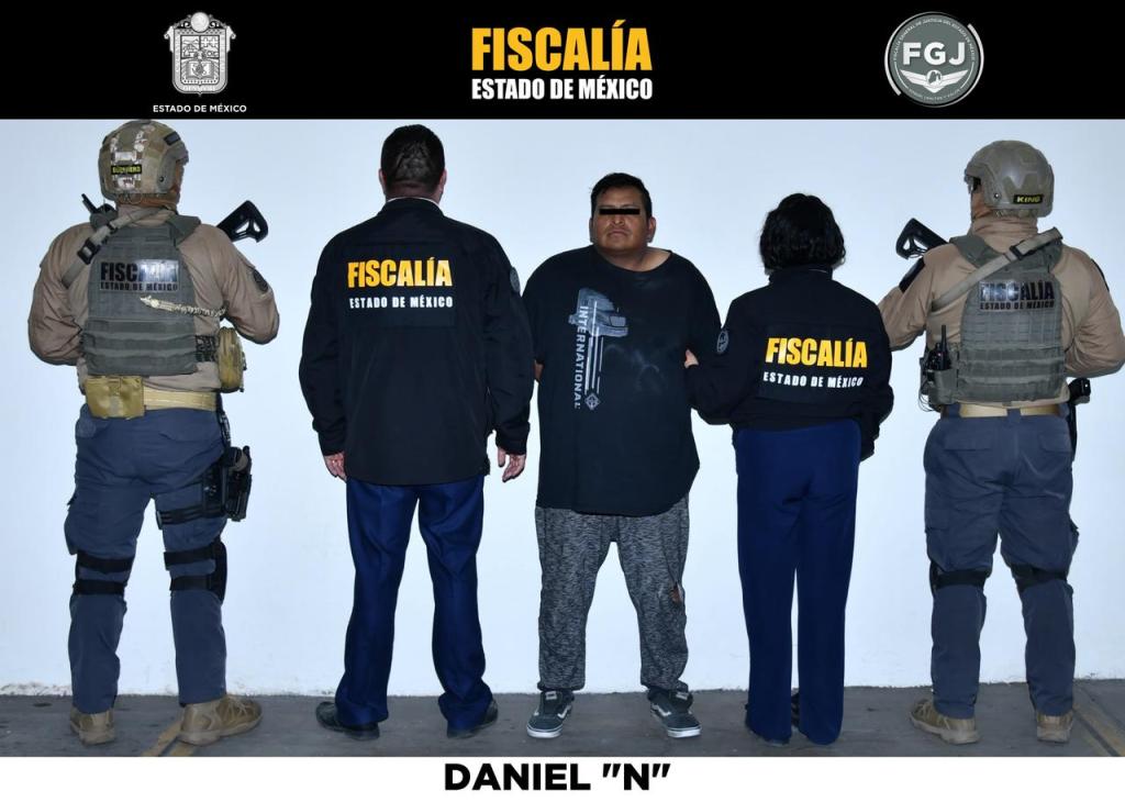 A man named Daniel 'N' standing between two law enforcement officers, all facing away from the camera, in a formal setting with a light background.