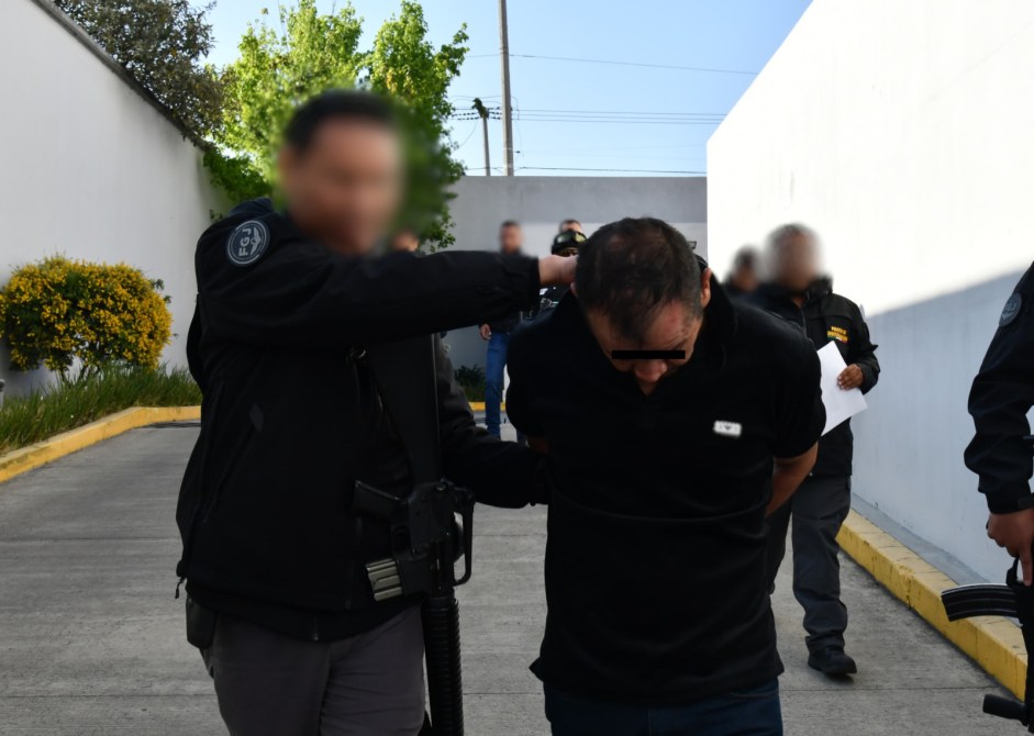 Detención de un hombre esposado por un policía en un entorno urbano.