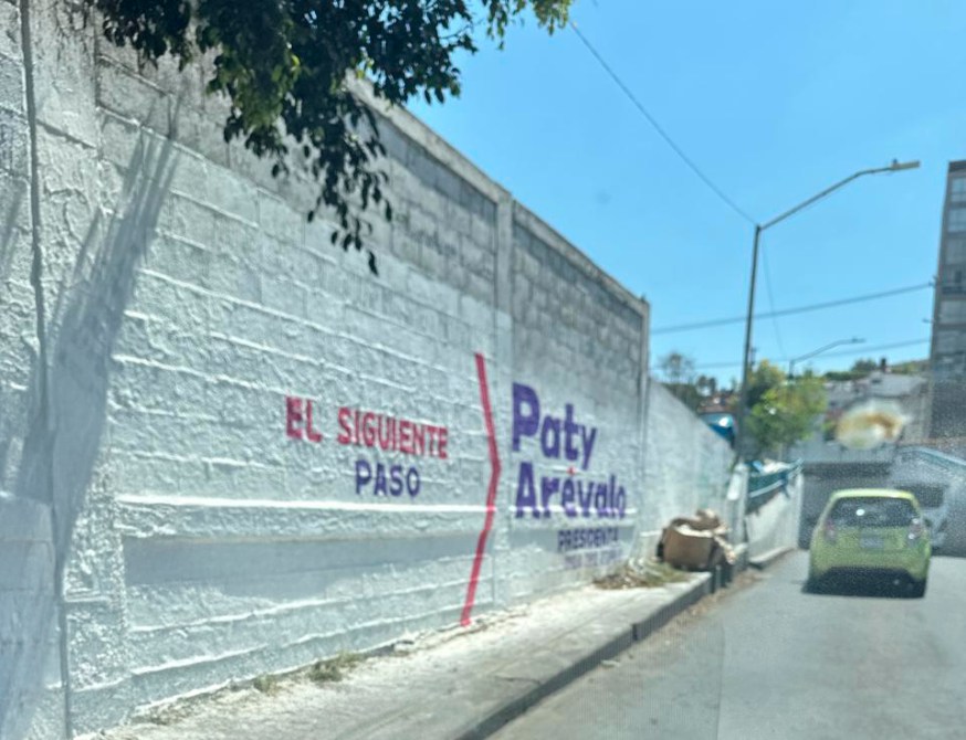 Mural que dice "El Siguiente Paso" y "Paty Arévalo Presidenta" en una pared blanca.