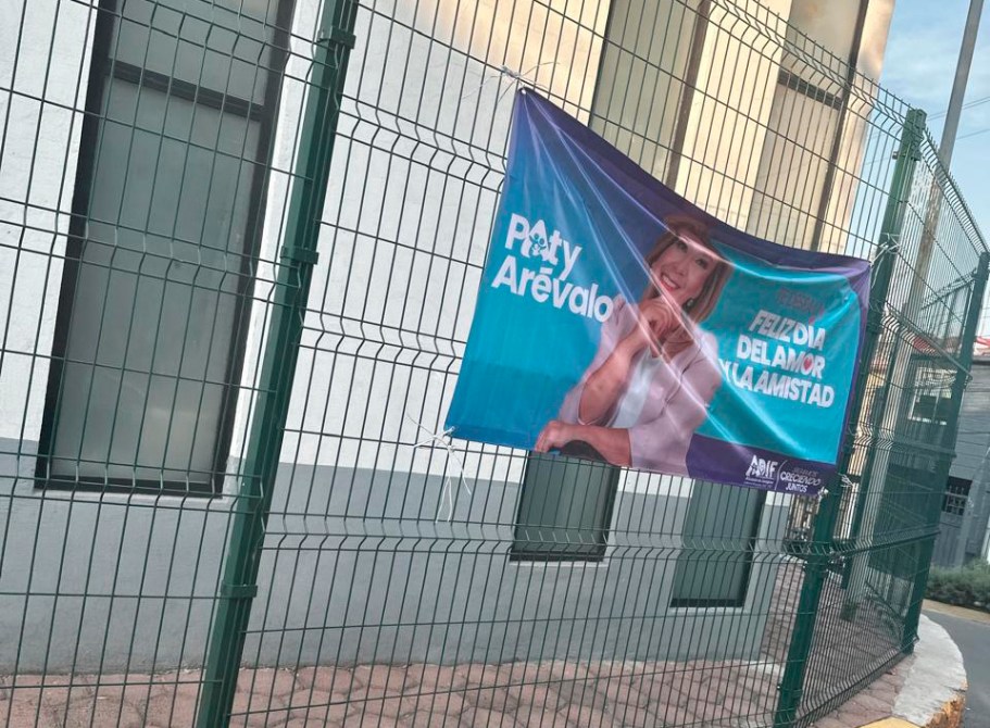 Banner de 'Paty Arevalo' con el mensaje 'Feliz Día del Amor y la Amistad' colgado en una cerca.