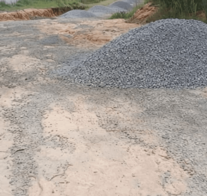 Montículo de grava en un terreno de construcción con huellas de maquinaria.