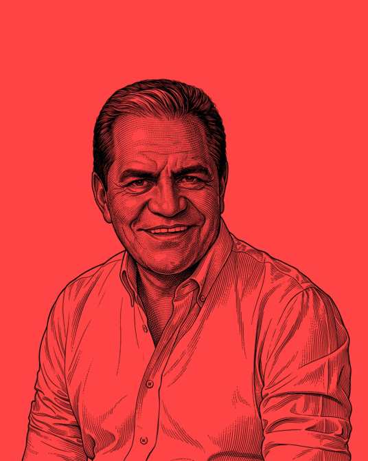 Retrato de un hombre sonriente con camisa blanca sobre un fondo rojo.