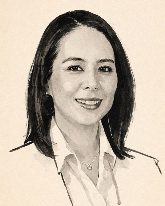 Retrato en acuarela de una mujer sonriente con cabello oscuro y lacio, vistiendo una camisa blanca y con un collar. El fondo es de un color claro y suave.