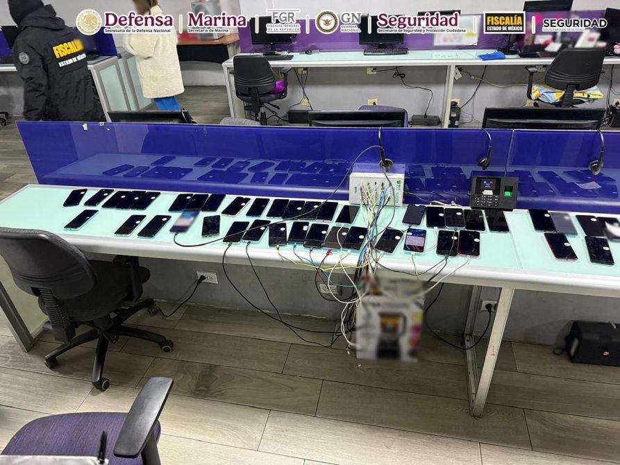 Mesa con numerosos teléfonos móviles conectados a un dispositivo, en un entorno de oficina o investigación.