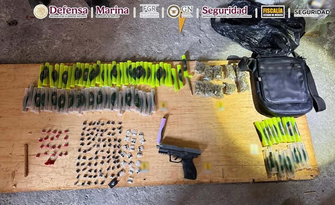 Mesa con armas, municiones y paquetes de sustancias en una bolsa negra.