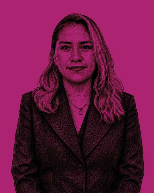 Retrato de una mujer con cabello largo y rizado, vestida con un traje oscuro, fondo de color fucsia.