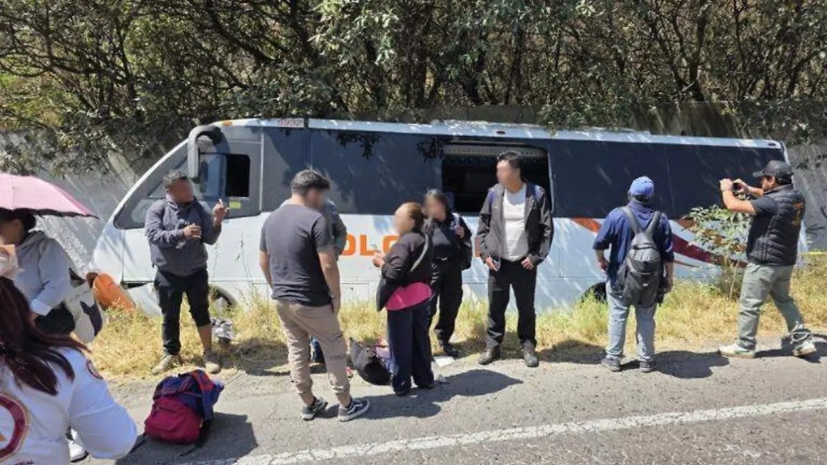 Grupo de personas reunidas al lado de un autobús detenido junto a la carretera.