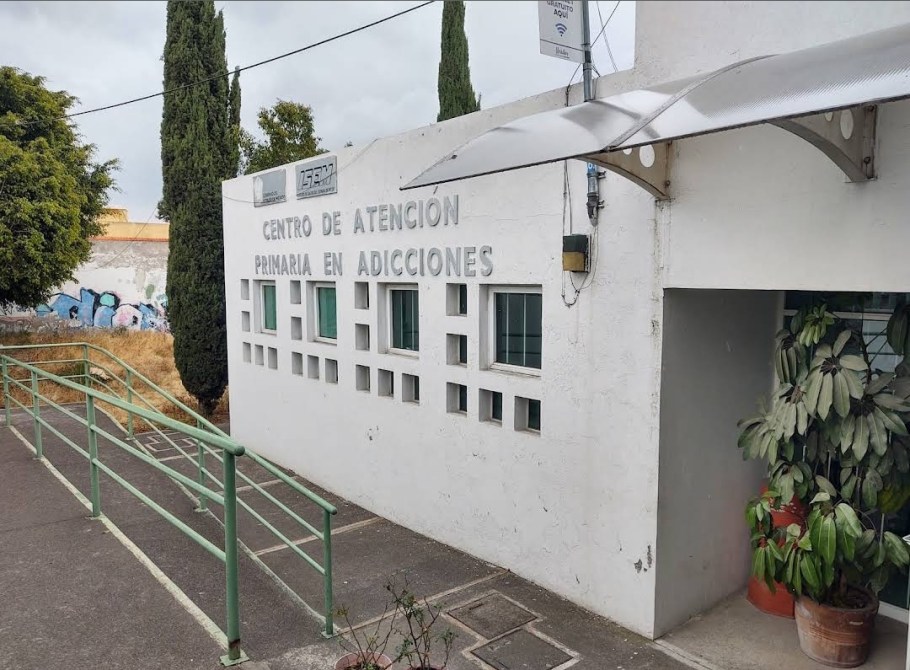 Fachada del Centro de Atención Primaria en Adicciones con rampas de acceso y plantas decorativas.