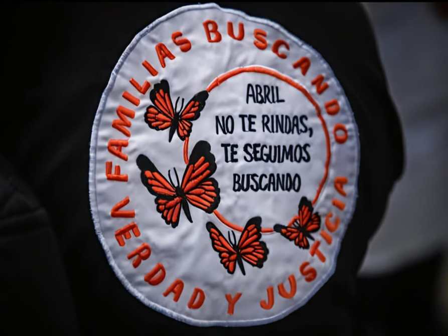 Parche de tela con mariposas y el texto: 'Abril no te rindas, te seguimos buscando' en un fondo blanco con la frase 'Familias buscando verdad y justicia'.