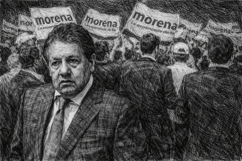 Hombre con expresión seria al frente de una multitud sosteniendo pancartas de Morena.