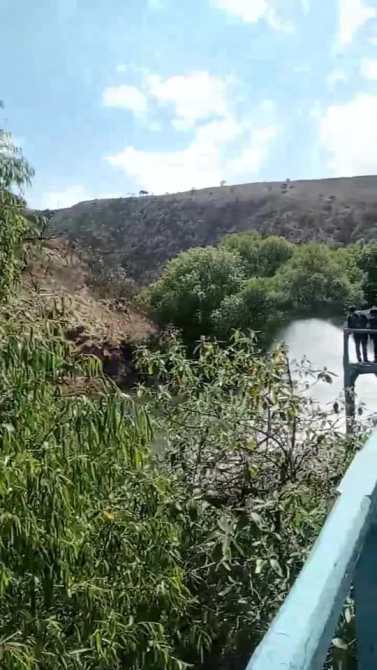 Vista de un río rodeado de vegetación y montañas bajo un cielo despejado.