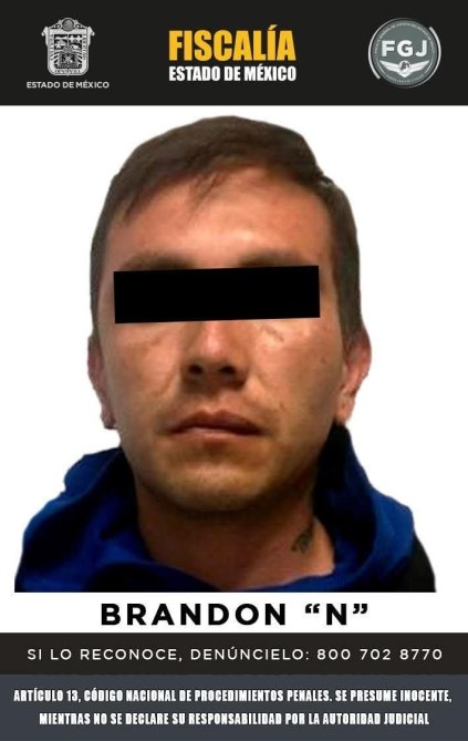 Fotografía de un hombre con cabello corto, visto de frente, con una camiseta azul y una chaqueta oscura. El fondo es negro con texto que indica que es buscado por la fiscalía del Estado de México.