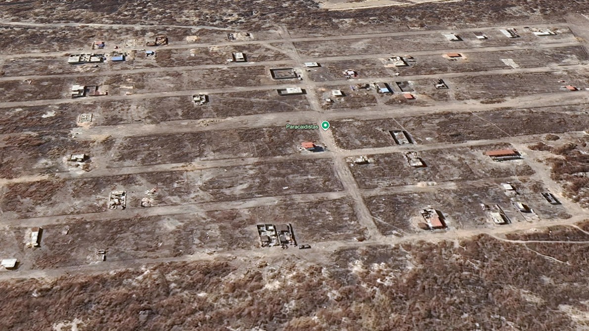 Vista aérea de un área destruida con estructuras de edificios y carreteras visibles, marcada por la falta de vegetación.