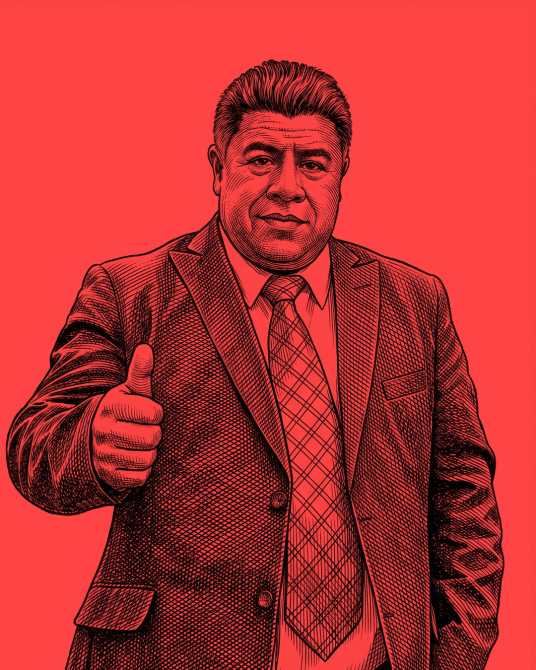 Retrato de un hombre con traje oscuro, con una sonrisa y el pulgar hacia arriba, sobre un fondo rojo.