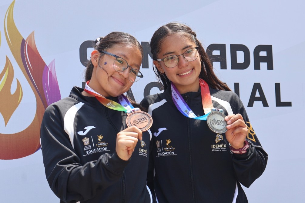 Dos jóvenes atletas posando con medallas de bronce y plata, frente a un fondo que dice 'Olimpiada Nacional'.