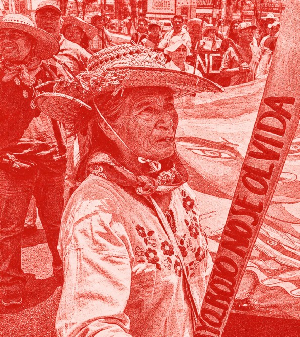 Mujer indígena con sombrero y vestimenta tradicional sostiene un cartel que dice 'NO SE OLVIDA' durante una manifestación.