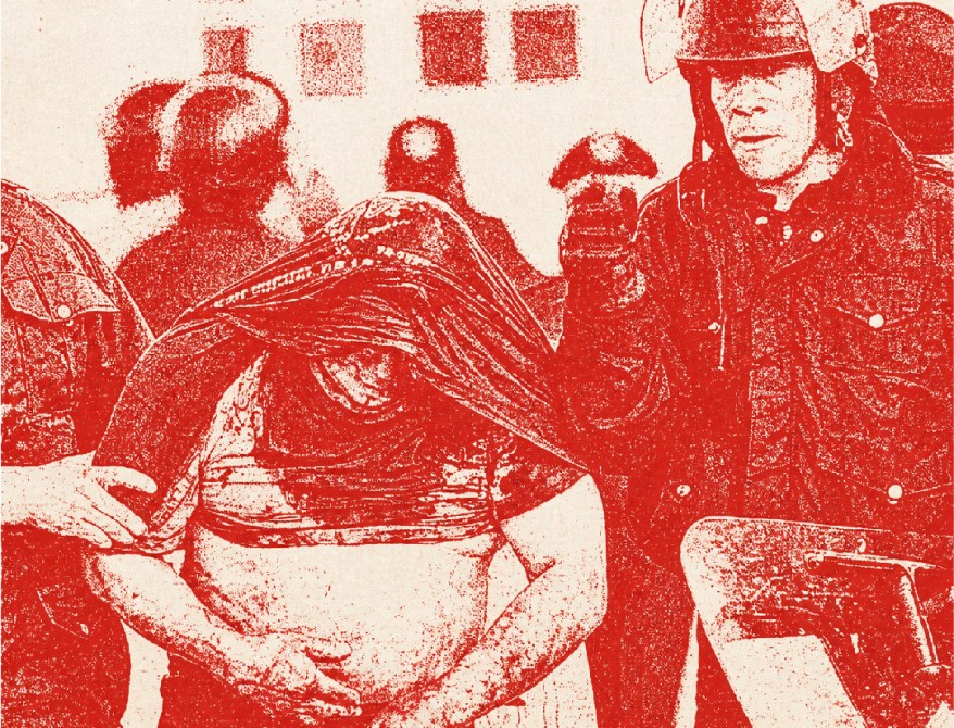 Imagen en blanco y negro con un filtro rojo que muestra a una persona con una tela en la cabeza siendo detenida por agentes de policía.