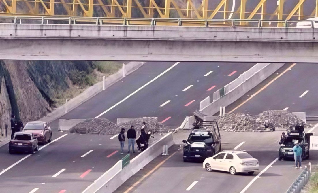 Bloqueo de carretera con un grupo de personas y vehículos en una autovía.