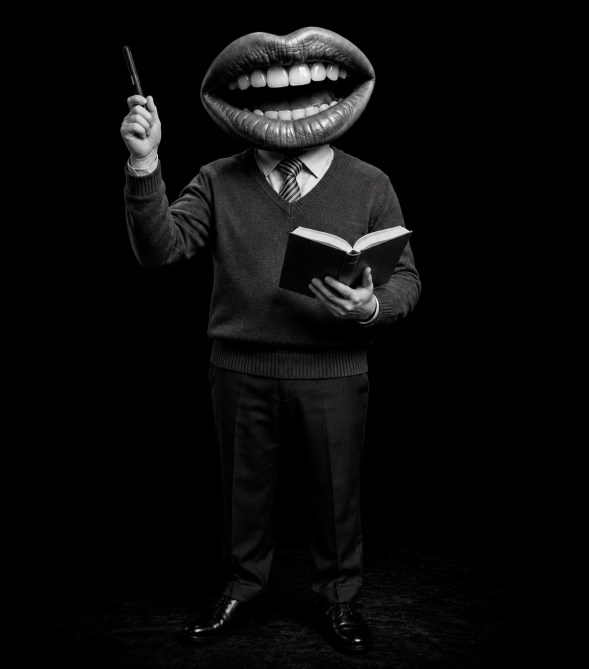 Hombre de pie con cabeza de boca grande, sosteniendo un libro y un bolígrafo, sobre fondo negro.